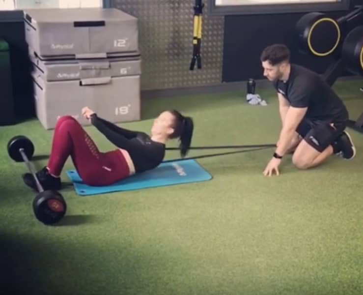 Mount Pleasnat client performing resistant band sit up during personal training workout in Swansea gym