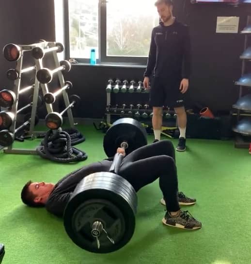 American football player from Fforestfach Swansea performing barbell hip thrusts during personal training in Swansea Gym