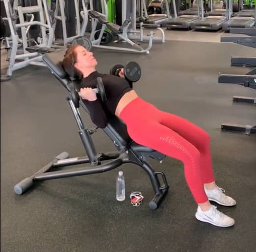 client from Tycoch Swansea performing seated bicep curls during personal training session in Swansea