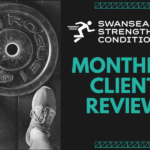Weightlifter standing over weights plate to represent Monthly Client Review with personal trainers at Swansea Strength and Conditioning