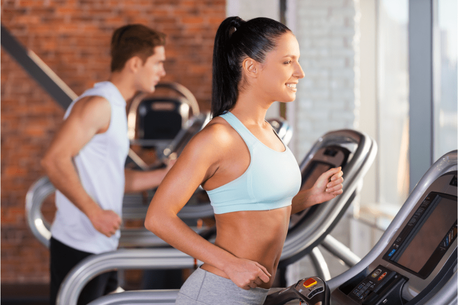 Slim fit woman doing personal training cardio on a running machine to lose weight