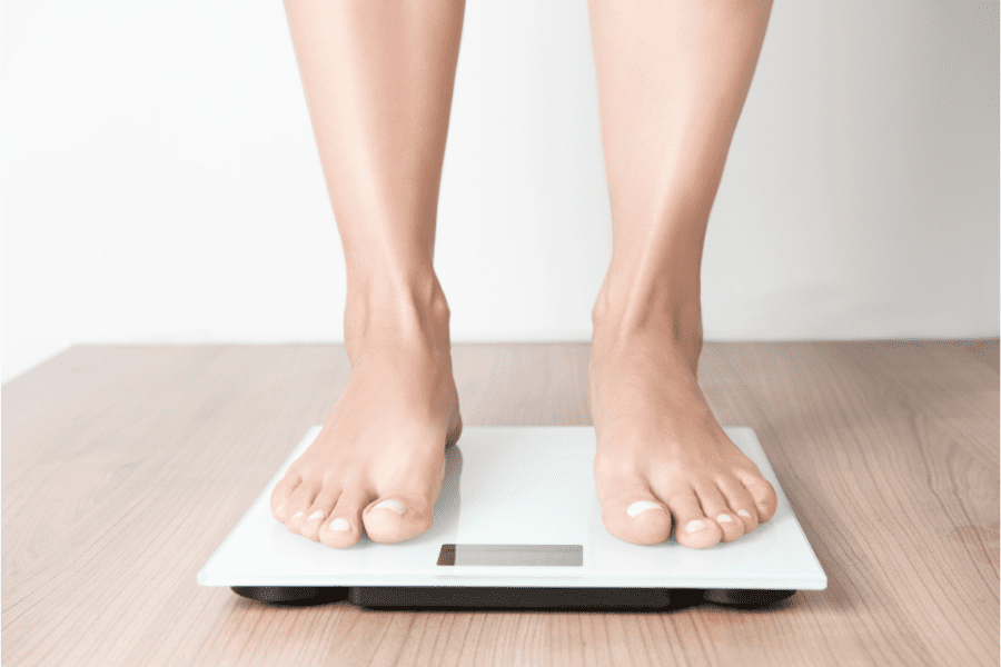 Photo of woman from calves down standing on weighing scales