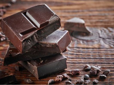 Mood Boosting foods Squares of dark chocolate on a brown table which is a great mood boosting food